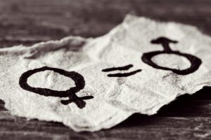 a female symbol, an equals sign and a male symbol drawn on a piece of paper depicting the women equality